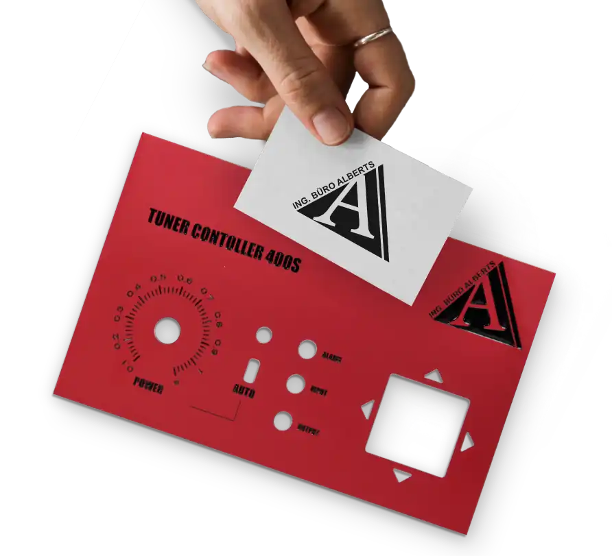 Eine Hand hält eine Visitenkarte mit einer Logoabbildung vor einer gefertigten Frontplatte, auf der das gleiche Logo als gravierte und schwarz ausgelegte Gravur zu sehen ist.