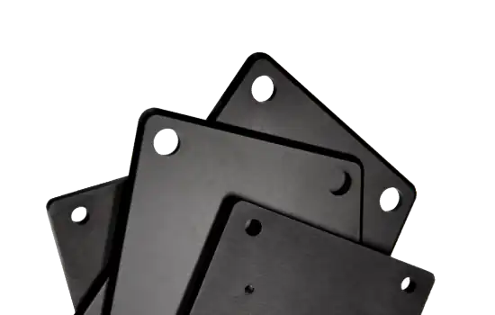 Vier kleine, aufgefächerte Frontplatten mit Bohrlöchern und schwarz-matter Eloxal-Oberfläche.